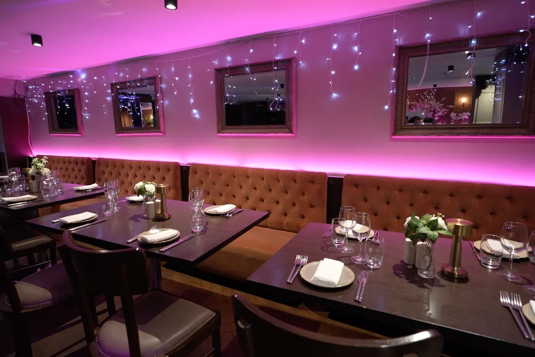 Rendezvous private dining room set with flowers, glassware and soft pink lighting