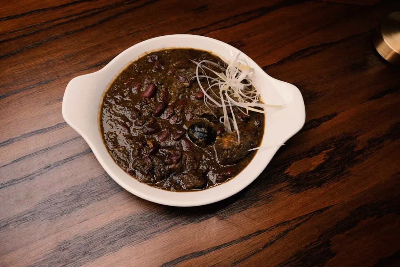 Persian herb stew with kidney beans served on a wooden table