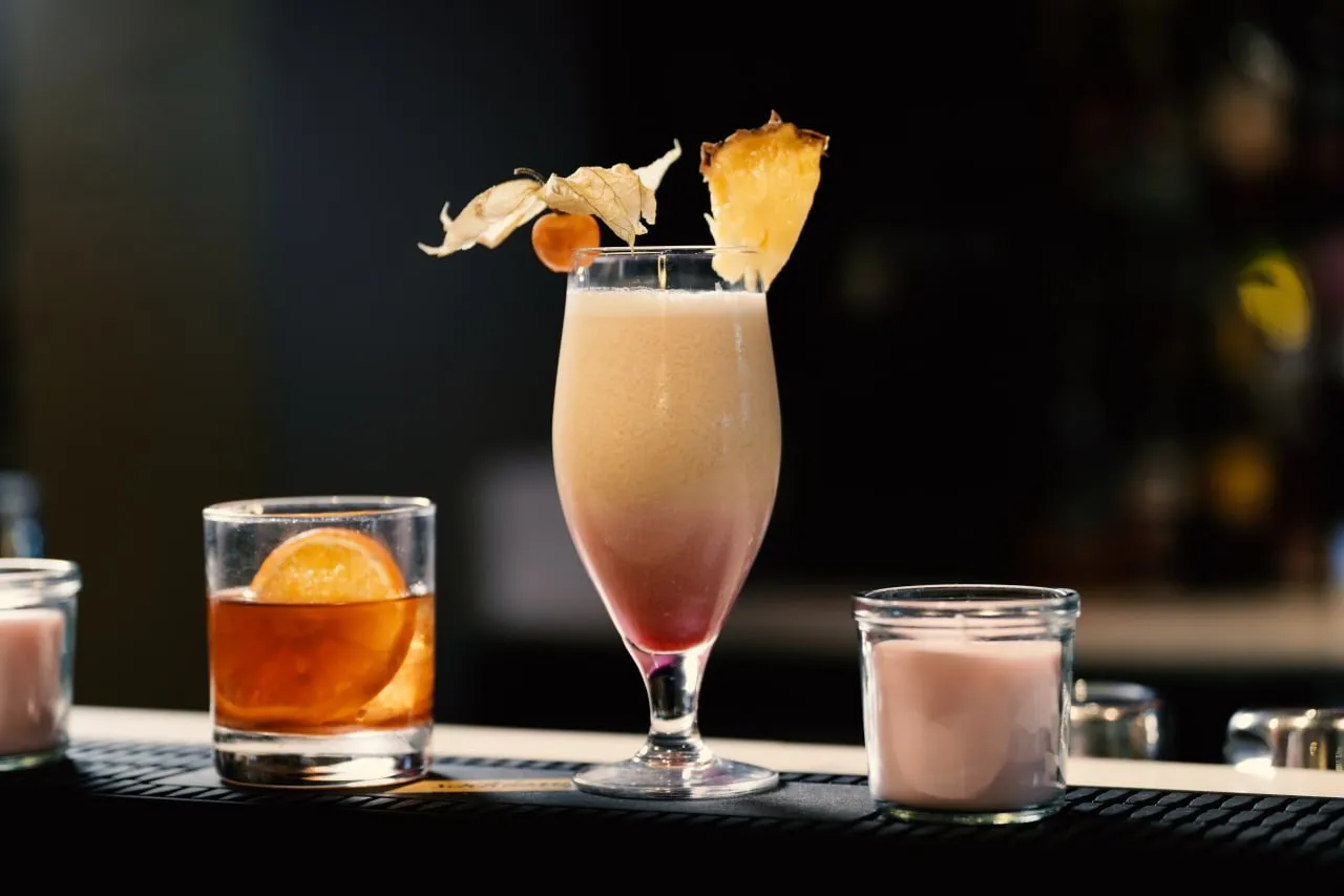 A tropical cocktail with pineapple and physalis garnish