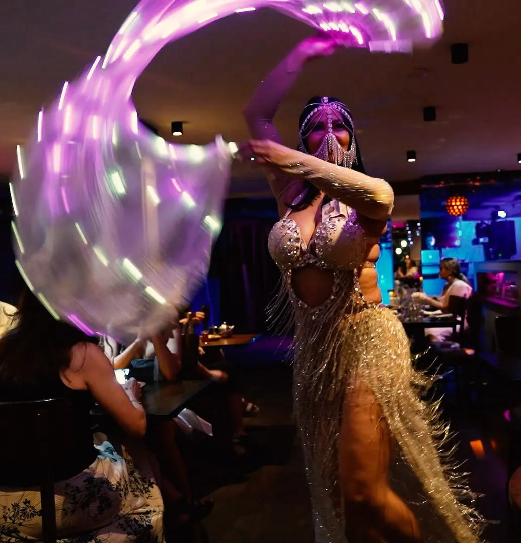 A belly dancer performing with illuminated fabric during a Rendezvous weekend event